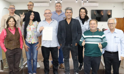 A foto mostra dez pessoas - entre os quais o homenageado ao meio, segurando a moção recebida, e os vereadores da Casa Legislativa de Alfenas - em pose olhando para o fotógrafo.