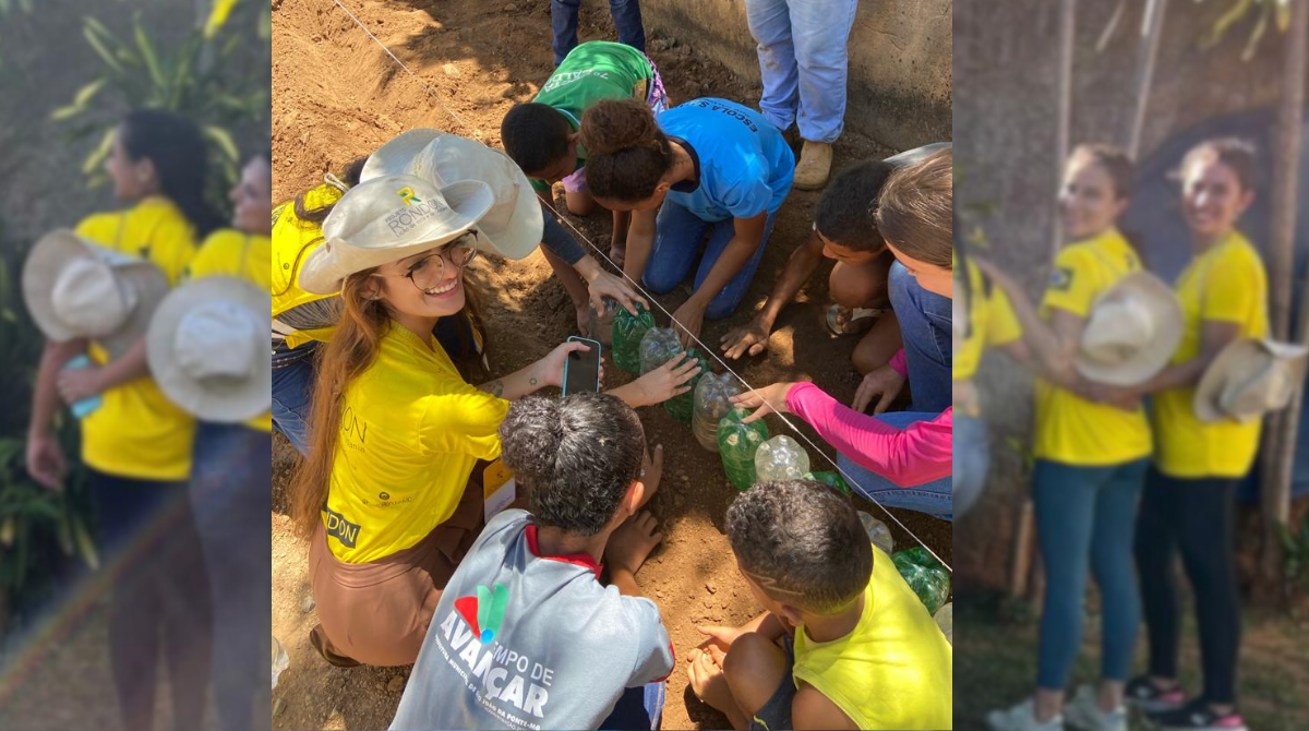 Na imagem, há uma foto das estudantes participantes do projeto rondon de 2024, no fundo. Elas estão abraçadas, de costas, uniformizadas, e a imagem está desfocada. Em cima desta imagem desfocada, de modo centralizado, contém outra foto de três rondonistas, uniformizadas, agachadas em uma horta, juntamente de cinco crianças, auxiliando na plantação de mudas em garrafas pet. Fim da descrição.