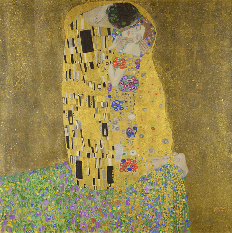 A imagem mostra a pintura chamada "O Beijo" de Gustav Klimt, em que um casal aparece se beijando, envolvido por mantos dourados e decorados com padrões geométricos e florais. O homem inclina-se para beijar a mulher, que está com os olhos fechados em uma expressão de serenidade. O fundo dourado destaca a intimidade da cena, enquanto o casal está de pé sobre um campo florido.