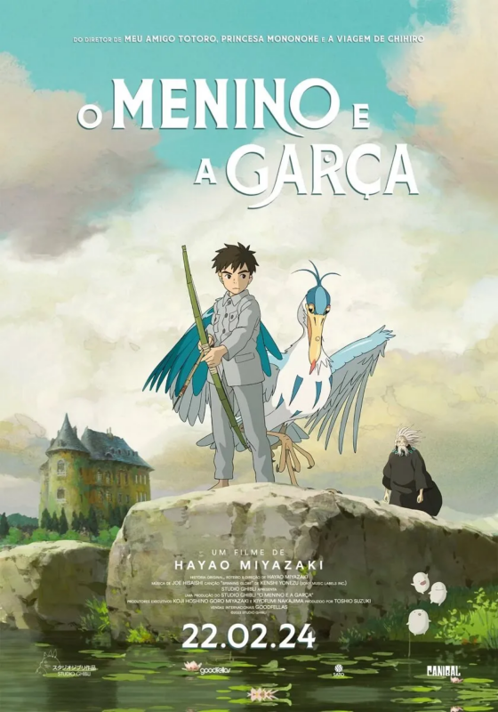 Imagem mostra o pôster do filme O Menino e a Garça, dirigido por Hayao Miyazaki. No centro da imagem, um menino de expressão séria veste um uniforme cinza, segura um longo bambu verde e está ao lado de uma garça azul com asas abertas e uma expressão humanizada. 